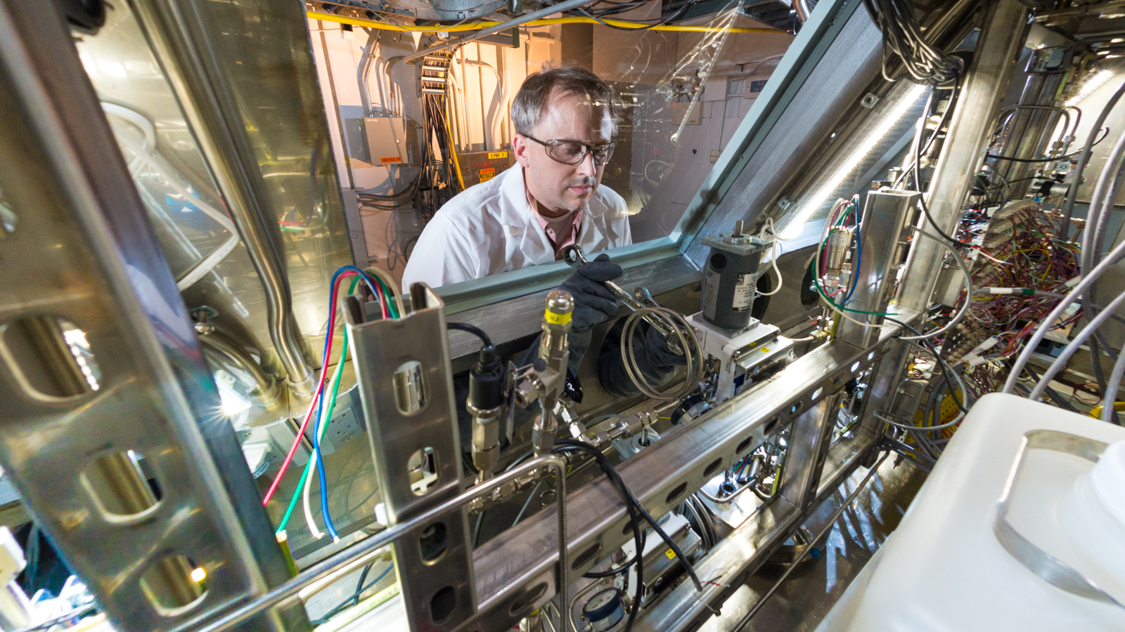 Principal chemist John Krebs performs final adjustments to an automated system designed and built by Argonne to process molybdenum-99 produced from an irradiated uranyl sulfate solution.
