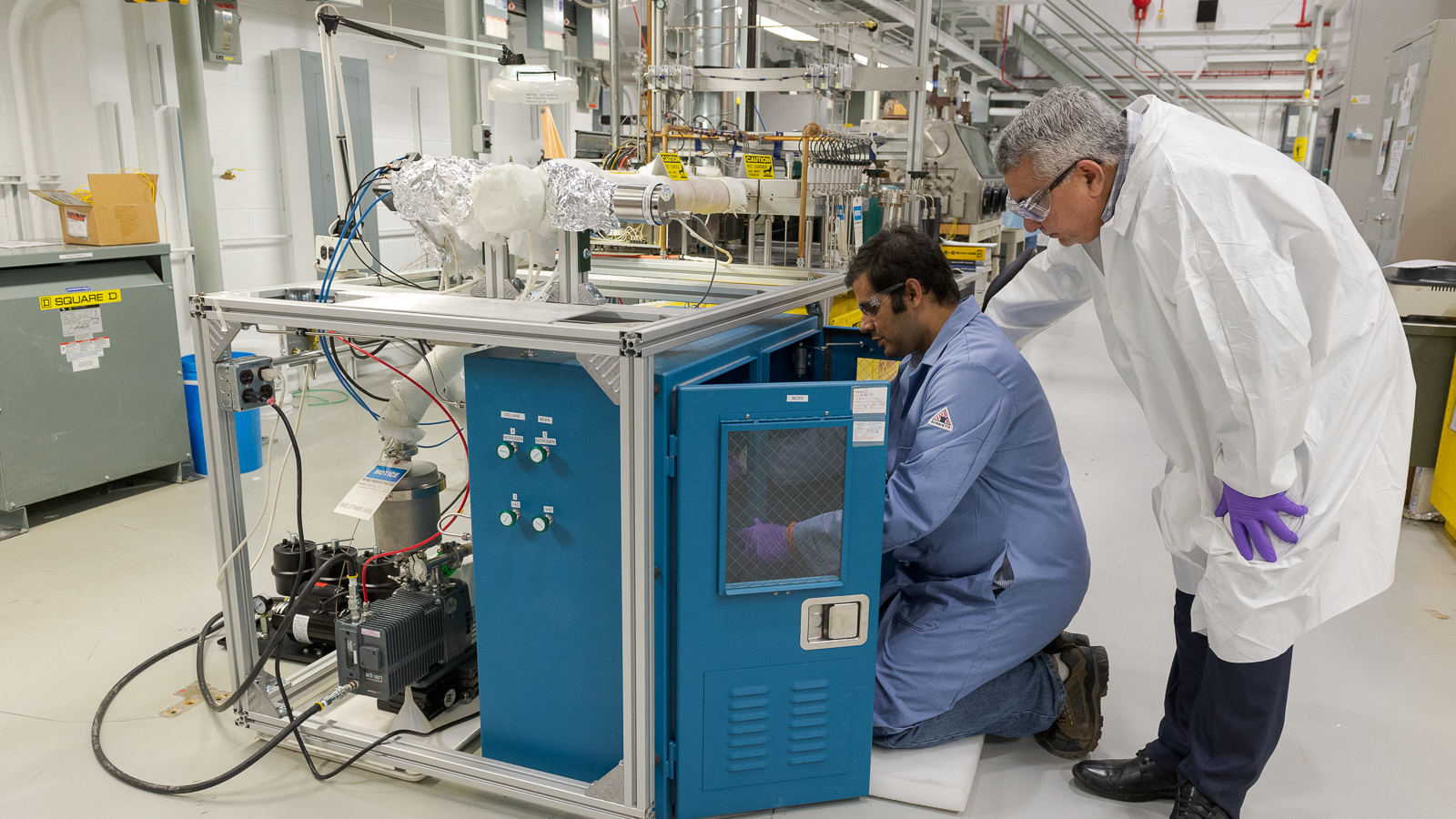Here, Bhattacharya and Yacout adjust lab equipment to deposit ALD-based nuclear coatings. (Image by Argonne National Laboratory.)