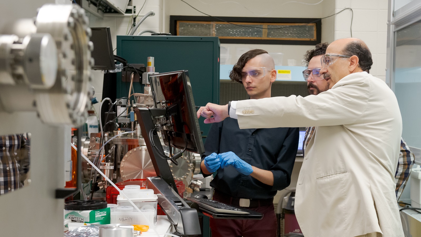 Argonne scientists at nanowire fabrication machine. Left to right: T. Polakovic, W.R. Armstrong and Z.-E. Meziani. (Image by Argonne National Laboratory.)