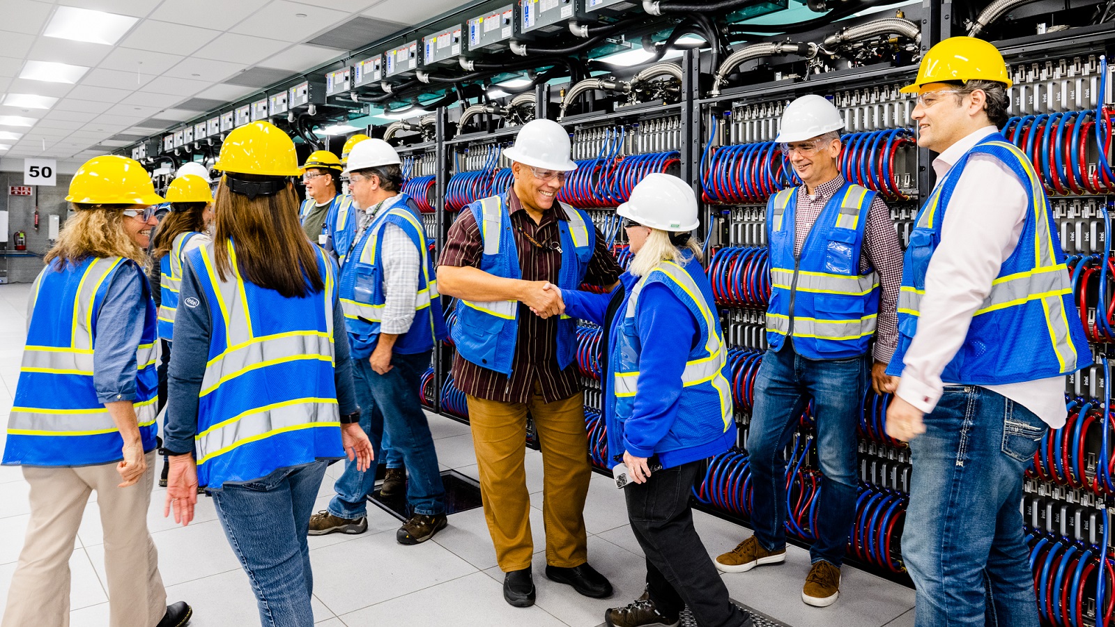 Technicians gathered in front of supercomputer. (Image by Argonne National Laboratory.)