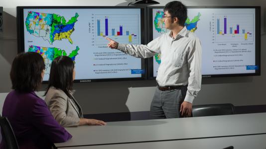 Argonne environmental analyst Hao Cai, environmental scientist Jiali Wang and climate scientist Yan Feng observe a U.S. map that plots the albedo effects observed across various agro-ecological zones.