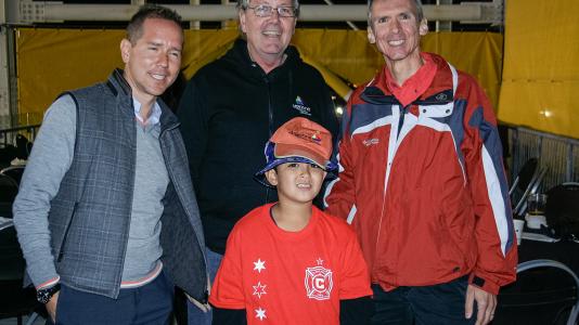 Chicago Fire owner Andrew Hauptman (left), Argonne Lab Director Peter Littlewood (middle), Congressman Dan Lipinski (right), and birthday boy and fundraiser Milo Greenspon (middle, front) pose at the Fire's Toyota Park stadium on Sept. 13, 2014. Photo credit: Justin H.S. Breaux. 