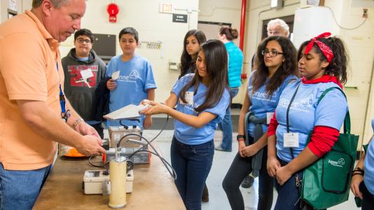 Argonne health physicist Mark Sreniawski uses a radiation meter to show Humphrey Middle School students how to detect low levels of radiation in everyday household items like alarm clocks and smoke detectors.