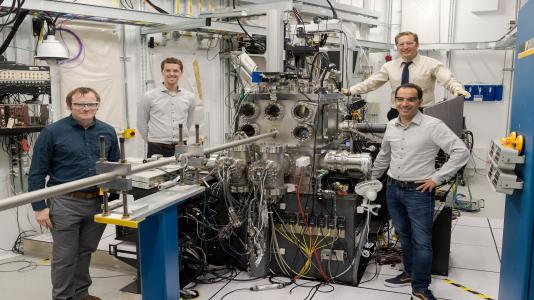 Argonne and University of Chicago scientists Joseph Heremans, Samuel Whiteley, Martin Holt, and Gary Wolfowicz stand by Argonne’s Hard X-ray Nanoprobe beamline, which was used for a new technique called stroboscopic Bragg diffraction microscopy to image sound waves in a crystal.