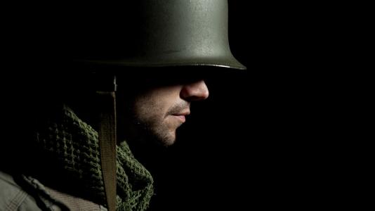 Side profile of soldier with green helmet and jacket