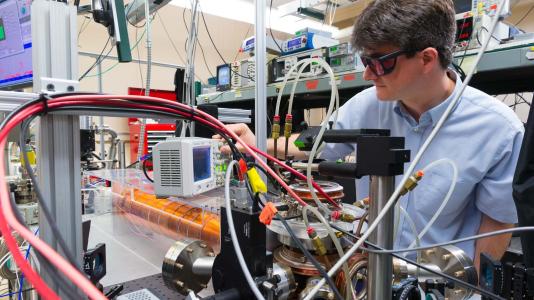 Scientist wearing goggles, using equipment. (Image by Argonne National Laboratory.)