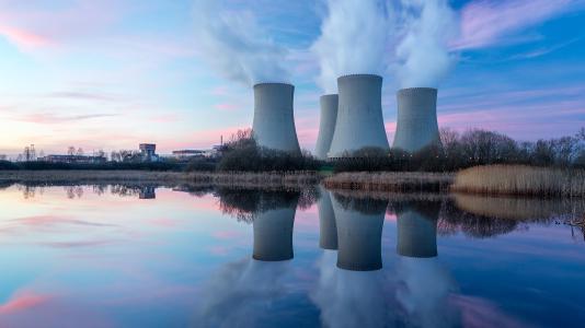 Photograph of nuclear reactors on waterfront horizon. (Image by Shutterstock/vlastas.)
