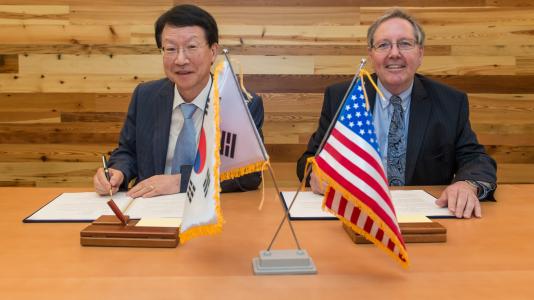 Jong Kyung Kim (left), President of KAERI, and Peter Littlewood, Argonne Laboratory Director, during a signing ceremony at Argonne.